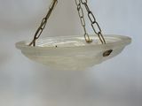 a person holding a glass bowl with chains hanging from it