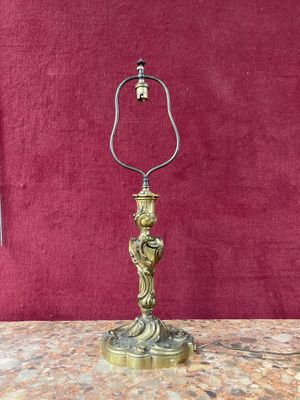 brass plated table lamp on a marble table with a red background