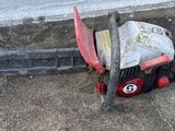 a chainsaw that is laying on the ground next to a building