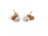 une paire de boucles d'oreilles en perles et diamants sur fond blanc