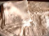 two napkins with a monogram on them sitting on a bed