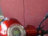 a red scooter that is parked in front of a red wall