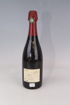 une vieille bouteille de vin posée sur une table blanche