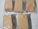 six sacs en papier kraft sont posés sur une surface blanche