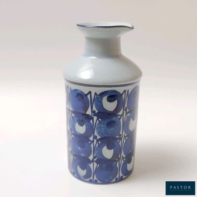 un vase bleu et blanc posé sur une surface blanche