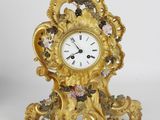 a gold clock sitting on top of a white table
