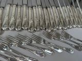 a lot of silver forks and spoons on the table