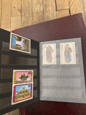 un livre ouvert avec des timbres, posé sur une table