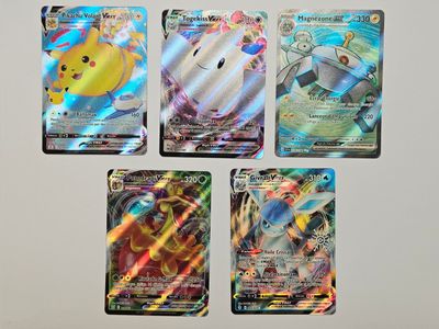 Quatre cartes Pokémon différentes sont posées sur une surface blanche