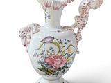 a white vase with pink flowers on it on a white surface