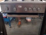 une personne debout devant un poêle dans une pièce