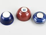 three blue and red vases sitting next to each other on a white surface