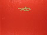 an old red book sitting on top of a table next to a cup of coffee