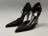 une paire de chaussures noires à talons hauts sur une surface blanche