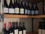 bottles of wine are lined up on a shelf in a wine shop