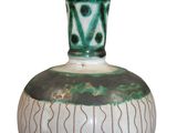 a green and white vase sitting on a white surface