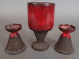 three red vases sitting next to each other on a table