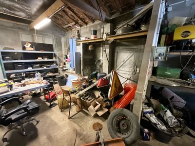 a garage with a lot of clutter and junk on the floor