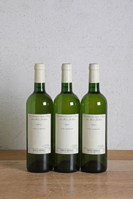 three bottles of wine sitting on top of a wooden table