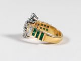an image of a diamond and emerald ring on a white surface