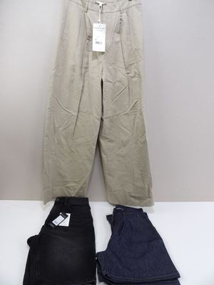 deux paires de pantalons et un pantalon posés sur une table