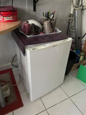 un petit réfrigérateur blanc dans le coin d'une cuisine