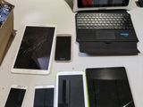 un ordinateur portable, une tablette, un téléphone et d'autres appareils électroniques posés sur une table