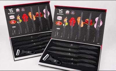 une paire de couteaux dans un coffret noir avec un manche rouge