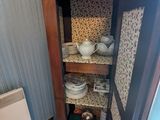 une armoire haute sur laquelle sont posés de nombreux plats