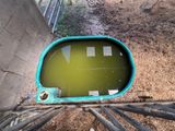 a green pool of water in the middle of a concrete wall