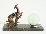a statue of a bird sitting on top of a marble ball