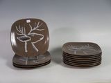 quatre assiettes ornées d'un motif représentant un cerf, posées sur une table