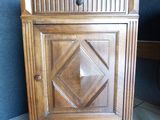 a small wooden cabinet with a door on top of it