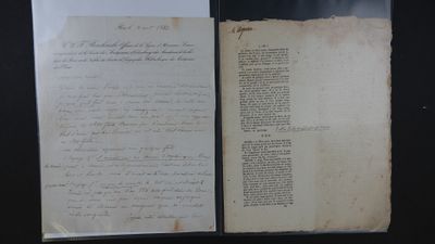 un vieux livre dont une page est couverte d'écriture, posé sur une table
