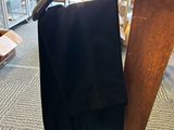 a black pants hanging on a hanger in a store