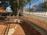 a wooden bench that is next to a metal fence