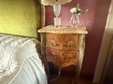 un lit avec une tête de lit verte sur laquelle est posée une lampe