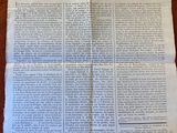 an old newspaper on a table with a piece of paper on it