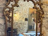 un miroir accroché au mur au-dessus d'une table sur laquelle se trouve un vase