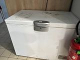 a white chest freezer sitting on the floor next to a fire extinguisher