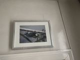 a picture hanging on the wall above a mirror