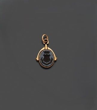 un pendentif plaqué or orné d'un visage en noir et blanc