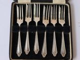 six fourchettes et une cuillère dans un étui posé sur une table