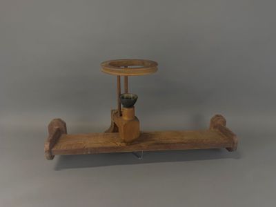 un petit avion en bois avec un système de pilotage, posé sur un socle