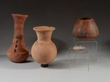 trois vases sont posés sur une table à côté d'une chaise