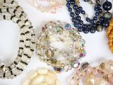 a lot of beads and bracelets on a white surface