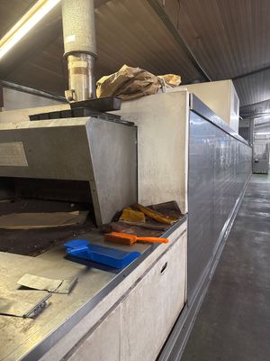 un tapis roulant dans une cuisine, sur lequel se trouvent tout un tas d'aliments