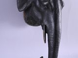 statue of an elephant ' s head with a pipe sticking out of it ' s mouth