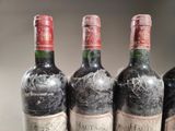 three bottles of red wine are lined up on a table