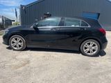 La Mercedes CLA noire est garée devant un immeuble.
